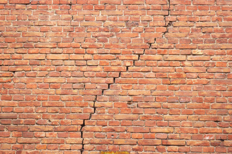 Large red brick crack in the wall